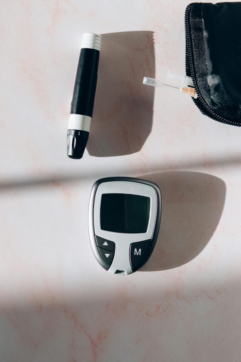 Close-up of a glucose meter and lancet for diabetes monitoring.